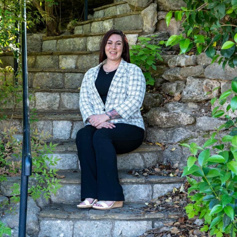 Rhiannon J Hernandez sitting on steps Rhiannon J Hernandez, Owner of the business sitting on steps.